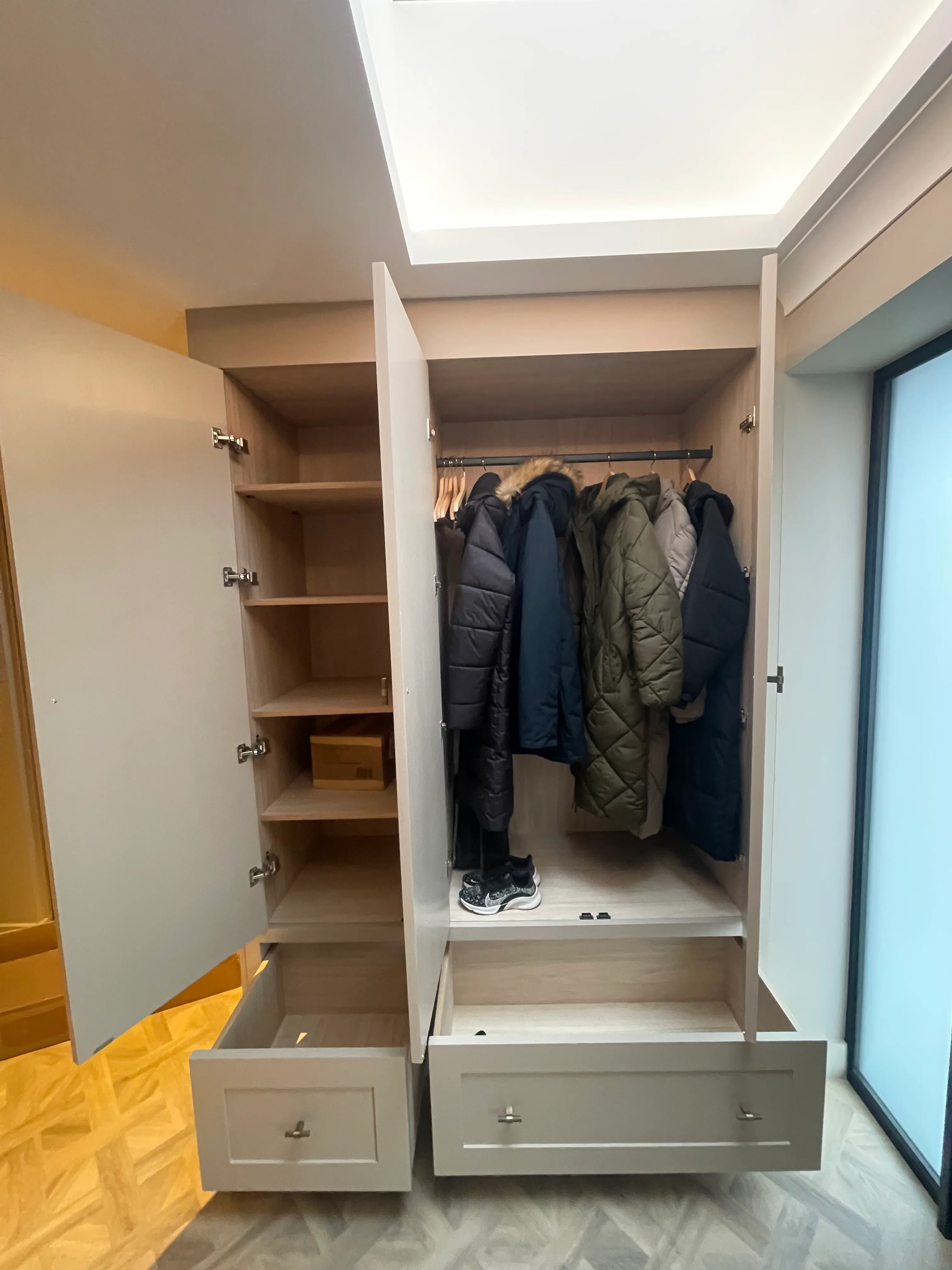 Walk-in wardrobe with full-height coat storage and shoe cubbies.
