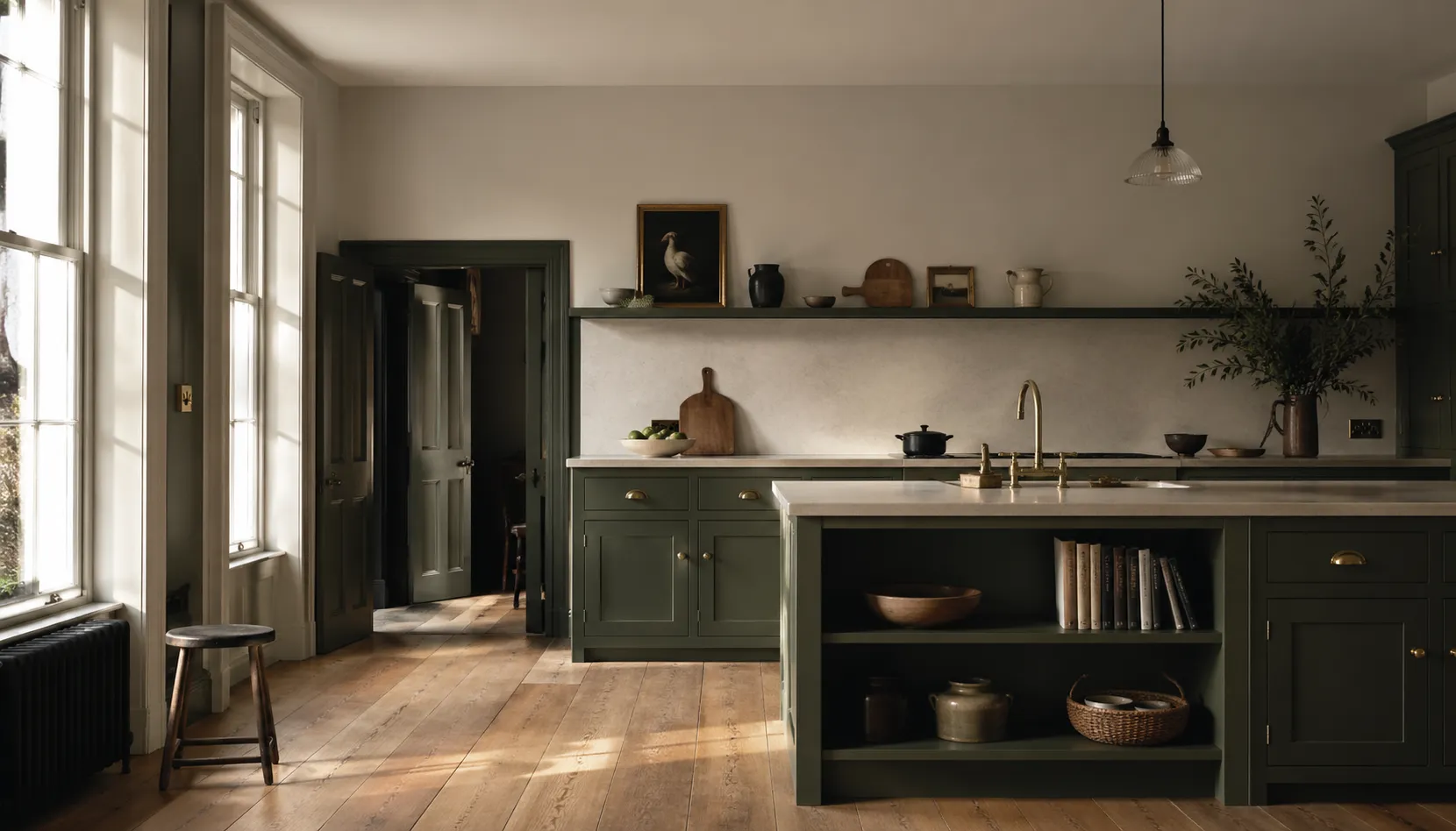 Bespoke Shaker kitchen in forest green with brass detailing, hand-painted in-frame cabinetry, stone island worktop, and wide-plank oak flooring.