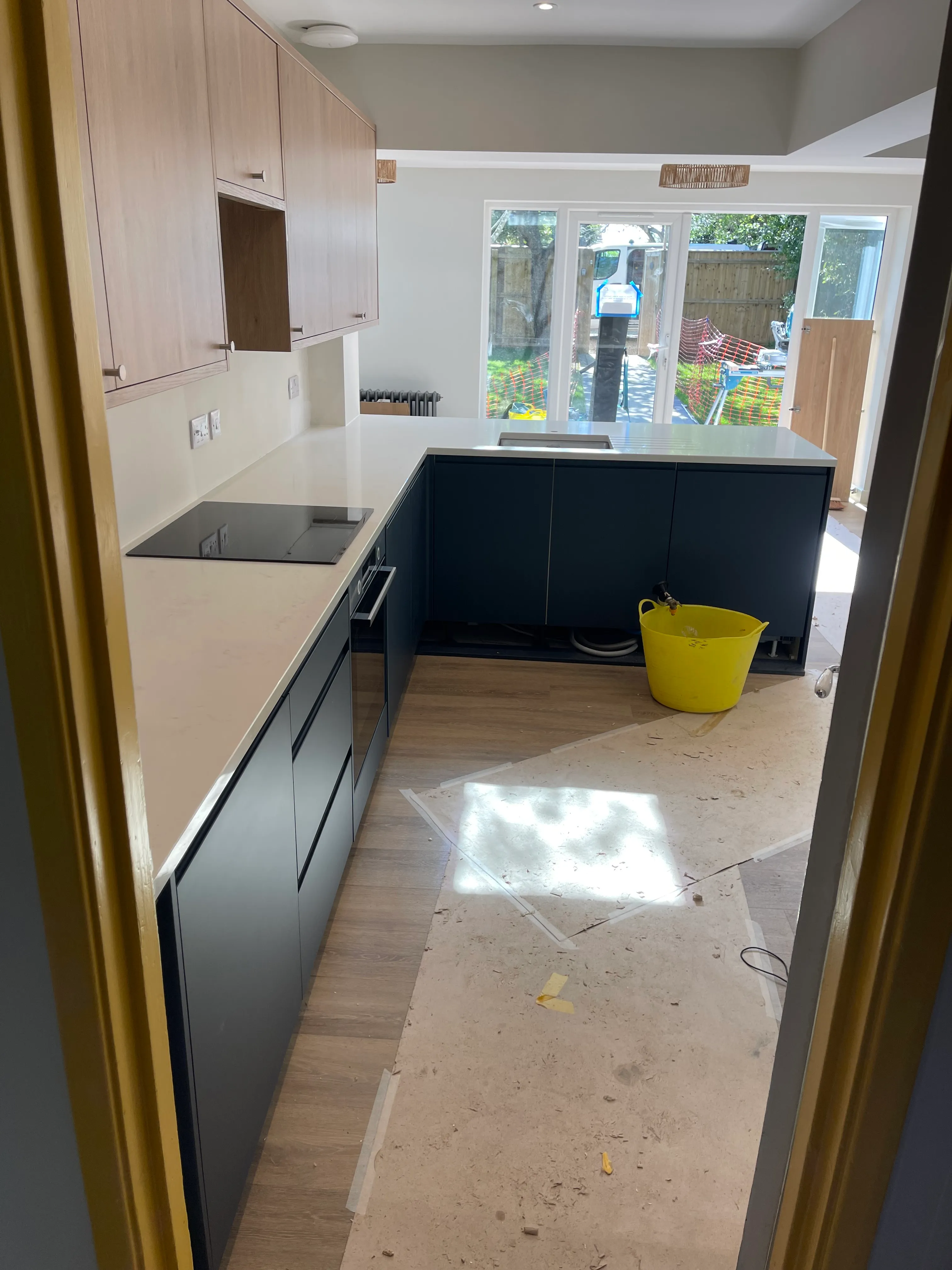 Contemporary charcoal and oak kitchen with a full-height book-matched marble splashback.