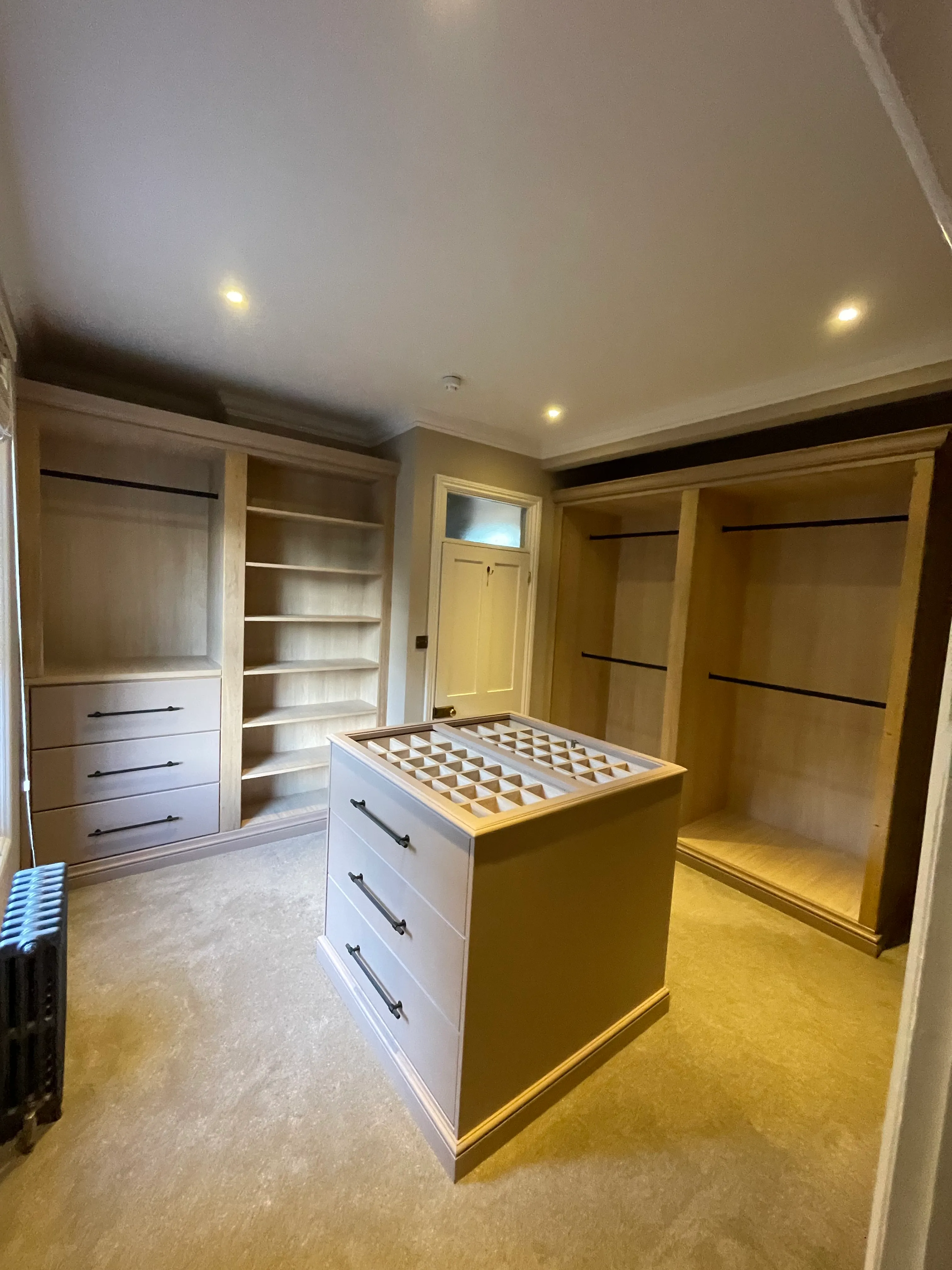 Side angle of the walk-in wardrobe joinery against gold venetian plaster.