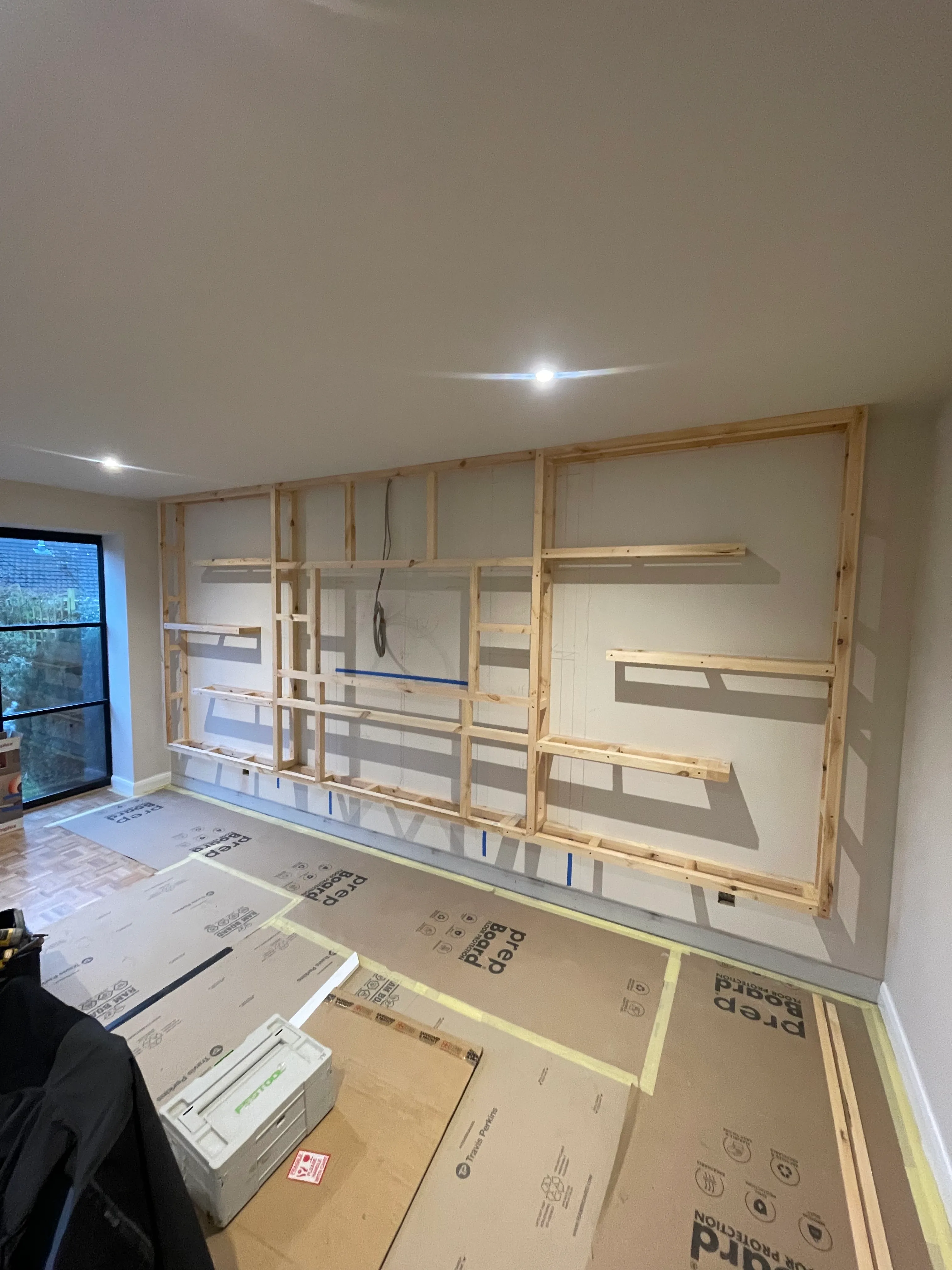 Stud partition framing built out to house the recessed bookcase media wall.
