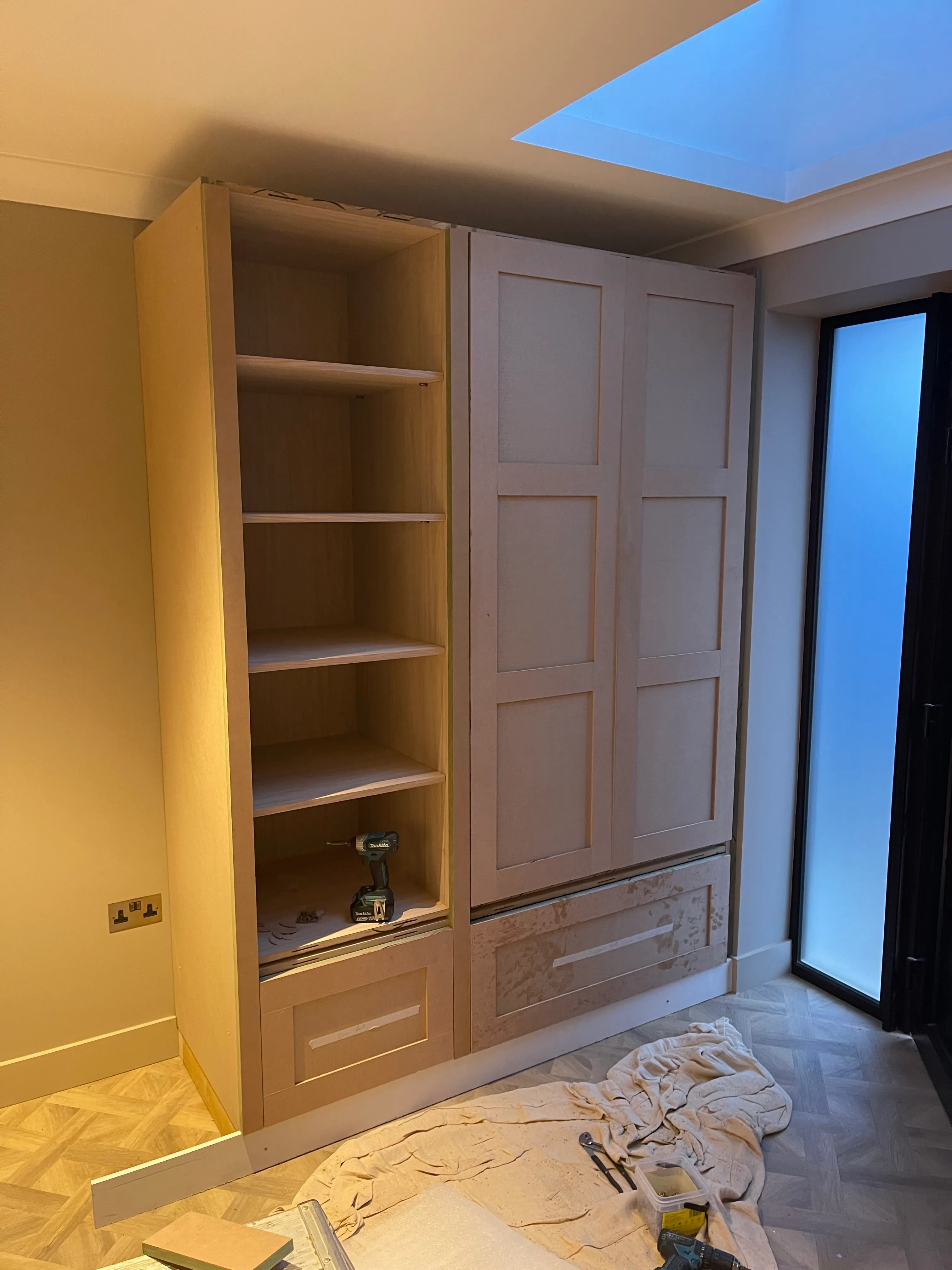 Hallway storage cabinet frame and shaker doors during installation.