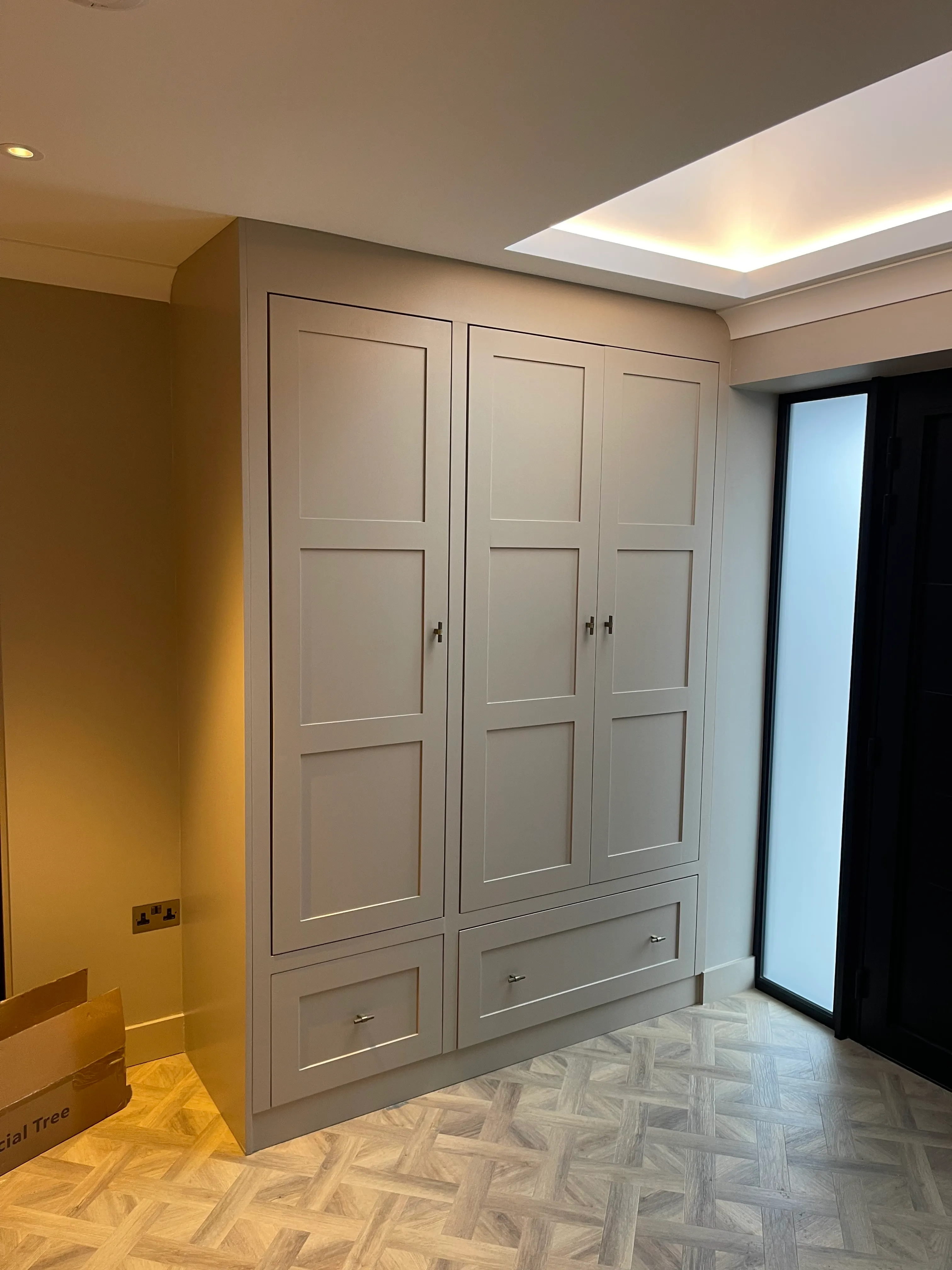 Hallway storage cabinet painted in soft white before final fit-out.